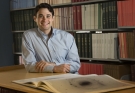 Joshua Sokol sitting at a desk in a library
